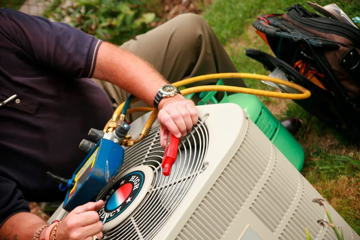 Technician checking refrigerant levels on residential AC unit